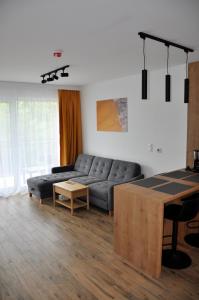 a living room with a couch and a table at Jantar Resort Apartament in Jantar