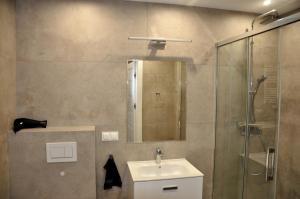 a bathroom with a sink and a shower at Jantar Resort Apartament in Jantar +17 photos