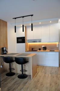 a kitchen with a counter and two bar stools at Jantar Resort Apartament in Jantar