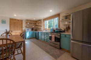 a kitchen with blue cabinets and a table and a refrigerator at Garden House in Livingston