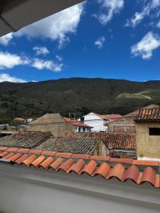 una vista de los tejados de los edificios con montañas en el fondo en Casa familiar RS, en Villa de Leyva