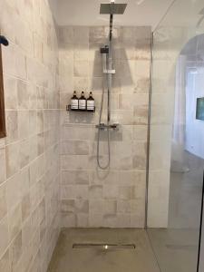 a shower with a glass door in a bathroom at Hebe la villa in Cogolin