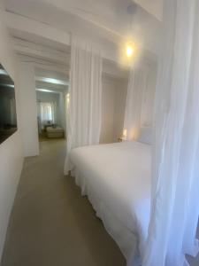 a bedroom with a white bed with a white canopy at Hebe la villa in Cogolin