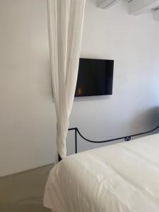 a bedroom with a bed with a tv on the wall at Hebe la villa in Cogolin
