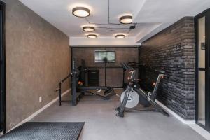 a gym with two tread machines and a brick wall at Yume B Side Pinheiros in Sao Paulo