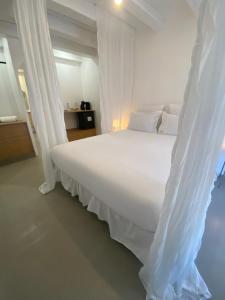 a white bed with white curtains in a bedroom at Hebe la villa in Cogolin +14 photos