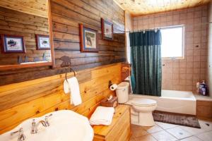a wooden bathroom with a tub and a toilet and a sink at Rancho Deluxe Lodge in Livingston +49 photos
