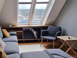 a living room with a couch and a chair and a window at Amunds Apartment in Bergen