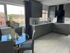 a kitchen with a glass table and a glass table and a tableablish at Blissful Barrys in Chesterfield