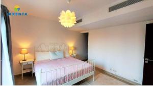 ein Schlafzimmer mit einem Bett und einem Kronleuchter in der Unterkunft Apartment for rent in Dawwār Abū Maḩrūs