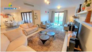 ein Wohnzimmer mit weißen Sofas und einem Tisch in der Unterkunft Apartment for rent in Dawwār Abū Maḩrūs