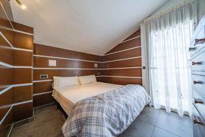 Un dormitorio pequeño con una cama y una ventana. en Casa Bohème, en Santa Susanna