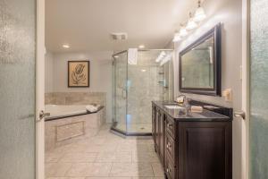 a bathroom with a shower and a sink and a tub at Red Coach Inn in Niagara Falls +232 photos