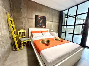 a bedroom with a large bed and a yellow chair at Apartamento Naranja in Bolnuevo