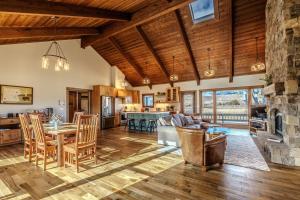 an open living room with wooden ceilings and a stone fireplace at Osprey Acres in Emigrant