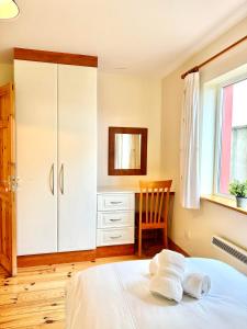 a bedroom with a bed and a desk and a chair at No 10 Ard Na Mara in Dingle