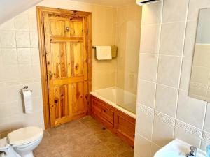 a bathroom with a toilet and a tub and a sink at No 10 Ard Na Mara in Dingle