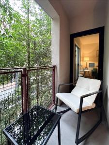 ein Balkon mit einem weißen Stuhl und einem Tisch in der Unterkunft Cozy 1BR apt in Hollywood w Pool, Gym and Parking in Los Angeles