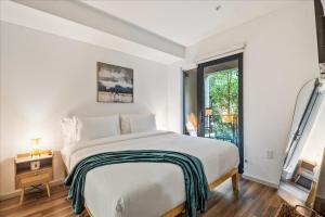 ein weißes Schlafzimmer mit einem großen Bett und einem Fenster in der Unterkunft Cozy 1BR apt in Hollywood w Pool, Gym and Parking in Los Angeles