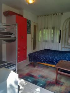 a bedroom with a bed and red cabinets and a table at MISU - HÁZA in Kerkakutas