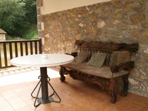 a table and a bench in a stone wall with a table and a table at Hostal Rural Onbordi in Lesaka