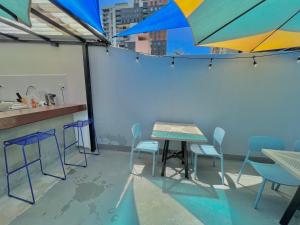 a patio with a table and chairs and an umbrella at Hotel Citadin Z10 in Guatemala