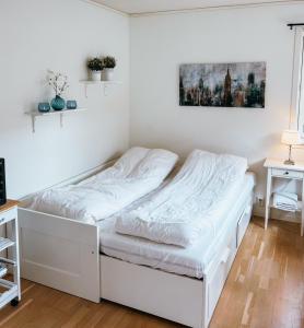 a white bed in a room with a desk at Newly renovated studio apartment - free parking and EV docking in Trondheim