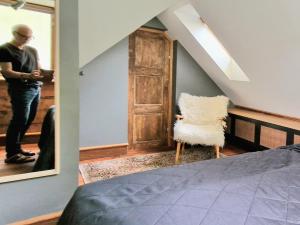 a man standing in a room with a chair and a mirror at Amunds Apartment in Bergen