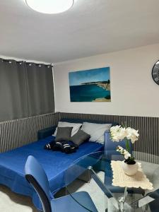 una camera da letto con un letto blu e un tavolo di Iris Chic Residence a Marsaskala Altre 10 foto