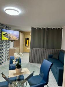 un soggiorno con divano blu e tavolo in vetro di Iris Chic Residence a Marsaskala