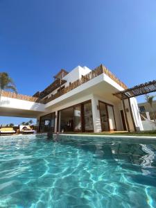 a house with a swimming pool in front of it at Casamaré Guajiru in Trairi