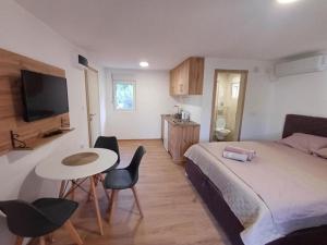 a bedroom with a bed and a table and chairs at Apartmani Marinee in Donja Jošica