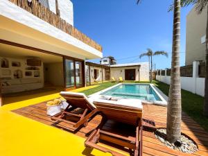 a villa with a pool and a deck with two chairs at Casamaré Guajiru in Trairi +33 photos