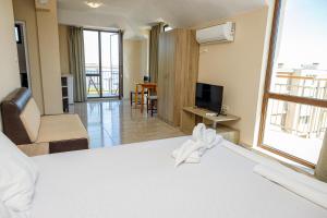 a hotel room with a bed and a television at Family Hotel Silitur in Ahtopol