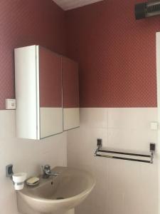 ein Badezimmer mit einem Waschbecken und einer roten Wand in der Unterkunft MAISON DE FAMILLE ENTRE MER ET CAMPAGNE à 5 MN DE LA PLAGE in Blainville-sur-Mer