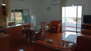 a living room with a glass table and chairs at Oriente Sole in Dhërmi