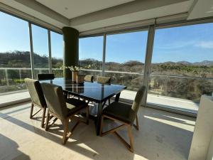 Higuera BlancaにあるDepartamento Sol y Mar Punta Mita, Beach Frontのテーブルと椅子と窓のあるダイニングルーム