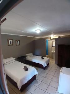 a hotel room with two beds and a bathroom at Mokala Gastehuis in Lephalale