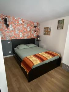 a bedroom with a bed with a floral wall at Cozy maisonette in Versailles 15 min from Paris in Versailles