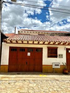 una casa blanca con una puerta de garaje roja en Casa familiar RS, en Villa de Leyva