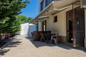 a patio with a table and chairs next to a building at Family Hotel Silitur in Ahtopol