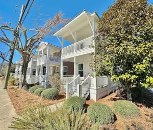 a large white house with trees and bushes at Stylish Cozy Family Cottage with Golf Cart - 1 mile to Dwntn Ocean Springs and beach in Ocean Springs
