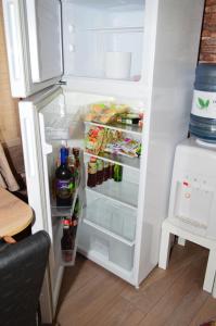 een open koelkast gevuld met veel eten en drinken bij YNA House in Boekarest
