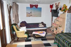 een slaapkamer met een bed, een stoel en een tafel bij YNA House in Boekarest