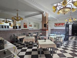 a restaurant with tables and chairs and a checkered floor at Hostal Sevillana Costa in Chipiona