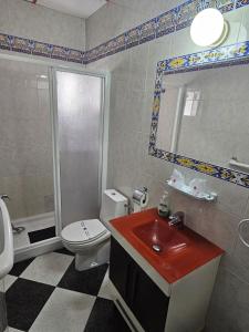 a bathroom with a sink and a toilet and a shower at Hostal Sevillana Costa in Chipiona