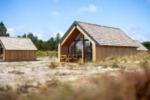 比耶勒高Bilberghus - Beyond Bed and Breakfast的田野上带玻璃窗的木屋