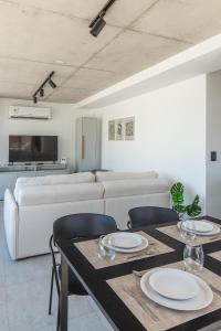a living room with a white couch and tables and chairs at Baliñas Boutique in Montevideo