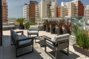 a patio with chairs and a table and plants at Baliñas Boutique in Montevideo