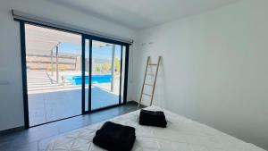 Un dormitorio con una cama y vistas a una piscina. en Casa Carica with heated pool in Lajares, en Lajares 29 fotos más